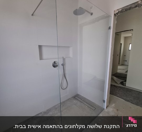 מקלחון זכוכית עם ראש מקלחת בחדר אמבטיה